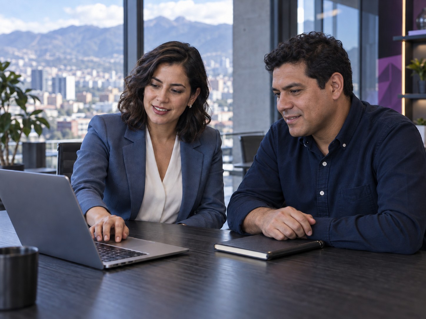 Asesora y empresario revisando juntos la gestión de su negocio en un portátil